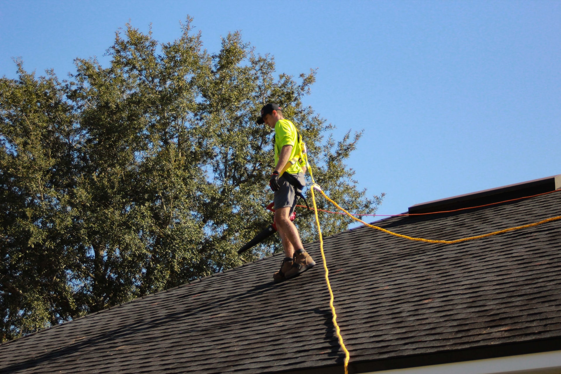 A roofer cleaning a residential roof